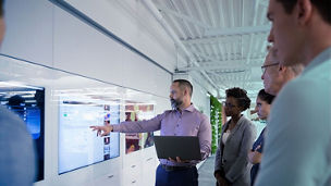 Business people in discussion looking at screen