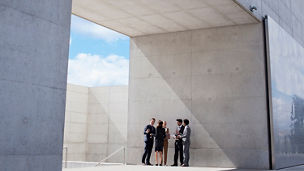 Business people standing under roof discussing