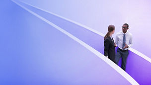 Businessman and businesswoman talking on modern staircase