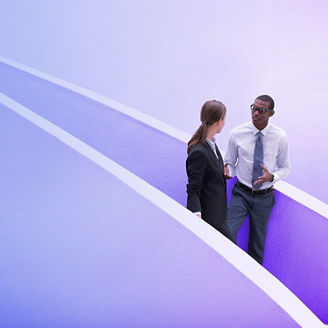 Businessman and businesswoman talking on modern staircase
