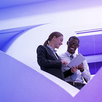 Businessman and businesswoman using digital tablet on modern staircase