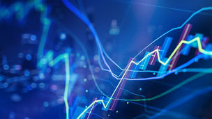 Close-up of colorful line graphs and candlestick chart elements over a blurred blue-toned background with circular light effects