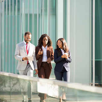 Business team moving along outdoor office glass wall. Business man and women walking outside, using tablet, talking, smiling, laughing. Discussion outdoors concept