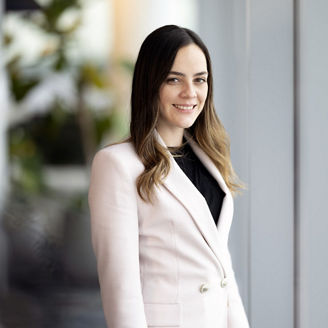 Business woman in white coat looking at camera