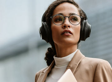 Businesswoman with headphones walking down the street