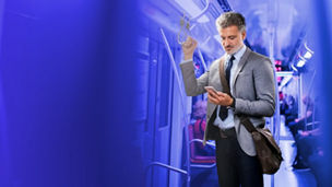 Businessman looking at phone in metro