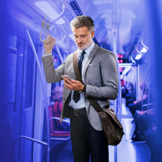 Businessman looking at phone in metro