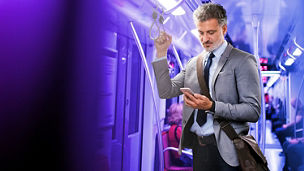 Man in metro kijkt naar telefoon
