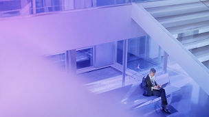 Mann sitzt auf Treppe und arbeitet an Laptop