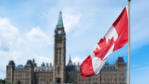 Canada flag flying outside parliament building