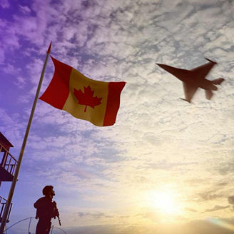 Canadian soldier guards tower with flag while CF-18 fighter jet flies overhead