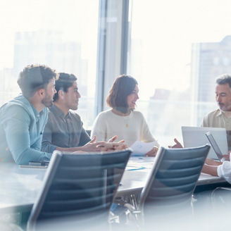 Diverse group of Business people during a meeting with copy space. They are sitting in a board room, All are casually dressed.