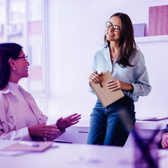Woman with glasses holding notebook and smiling