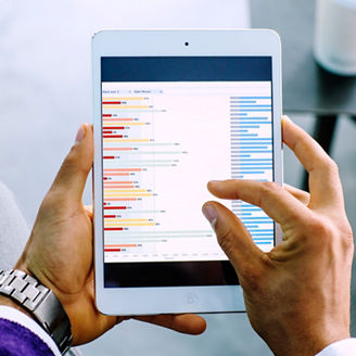 Mixed race businessman examining graph on digital tablet