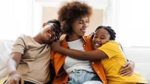 A family hugging on a sofa