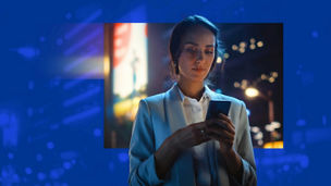 A person in a shirt and jacket looking at their phone