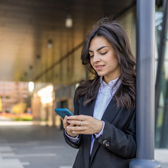 A girl in a suit checks her emails in mailbox and makes a business meeting on her mobile phone.