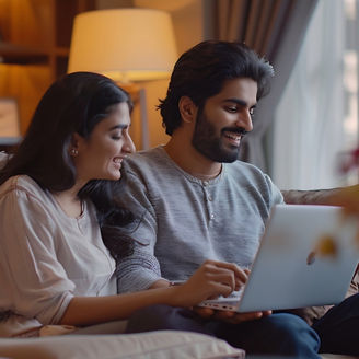 Planning vacation Cute happy millennial indian couple searching hotel and resort online using laptop sitting on couch in cozy living room interior at home free space : Generative AI