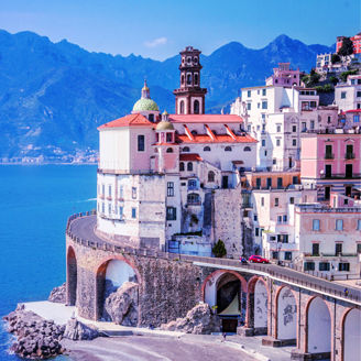 City besides an ocean with mountains