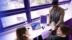 Three people in a meeting shaking hands