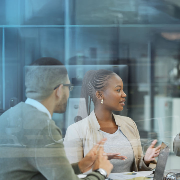 People sat around a table with laptops and documents