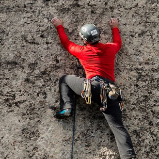 Climber in red climbing a rock