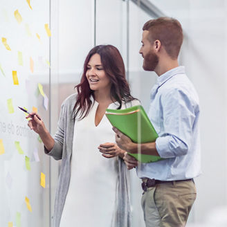 Colleagues having a discussion near a glass with sticky notes