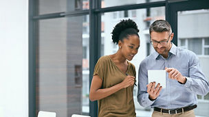 Colleagues smiling and looking at tablet