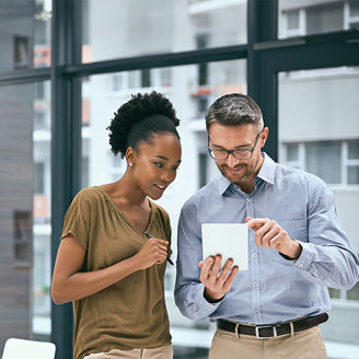 colleagues smiling and looking at a tablet