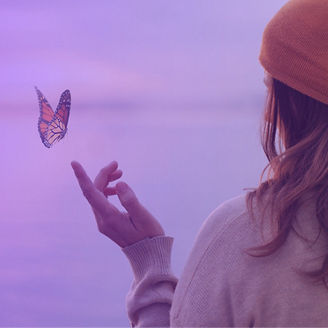 Clourful butterfly landing on a woman's hand