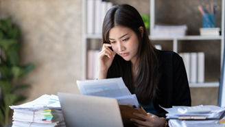Young concentrated businessowman working on her project while sitting in her modern office room.