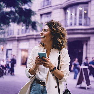 Cheerful travel blogger rejoicing at touristic street using cellular device for roaming networking during solo vacations, funny hipster girl with mobile technology laughing in international city; Shutterstock ID 1854949234; purchase_order: Asvisory assurance mkt; job: anne rouschop; client: ai campagne