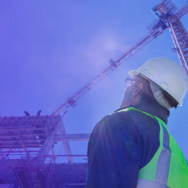 Construction worker looking a building in sunlight banner