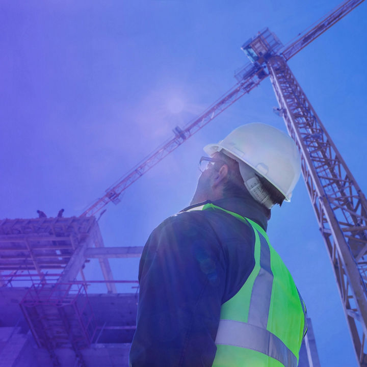 Construction worker looking a building in sunlight