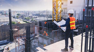 Smart civil architect engineer inspecting and working outdoors building side with blueprints. engineering and architecture concept.