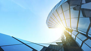 View of twisted glass building on blue sky background,Business concept of future architecture,looking up to the light on the top of building. 3d rendering.