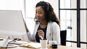 A man in the street smiling at his phone