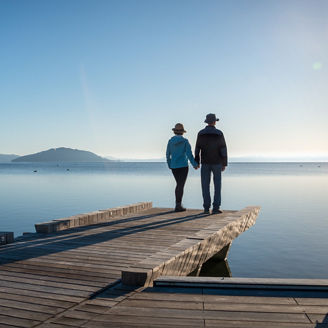 Couple holding hands, standing on the lakefront boardwalk, Rotorua.