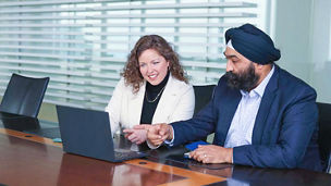 Coworkers looking at laptop in meeting