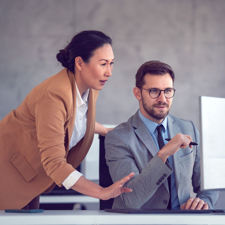 Coworkers working together on desktop
