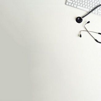 Top view of the white desk in doctors office with Stethoscope and computer keyboard. The image has white copy space to add your advertisement content for website, web banner. No one human face or body part are included in the frame.