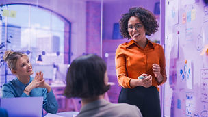 creatieve business vrouwen met elkaar in overleg voor whitebord