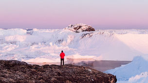 Man standing by a lake with mountain view