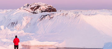 Man standing by a lake in the mountains