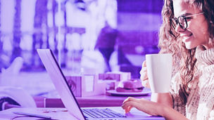 Woman looking at laptop while drinking coffee