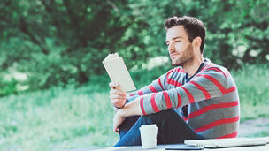 mlady muz citajuci knihu