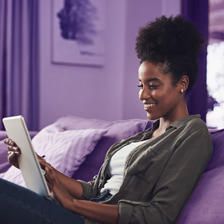 Happy, home and black woman on sofa on tablet for social media, online shopping and internet. Relax, rest and person on digital tech for reading website, news and research on weekend in living room.