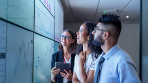 Three cyber security professionals look at large screen