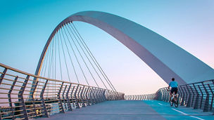 Cyclist riding on suspension bridge
