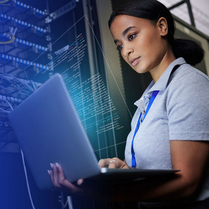Professional using laptop in data center with servers and code overlay